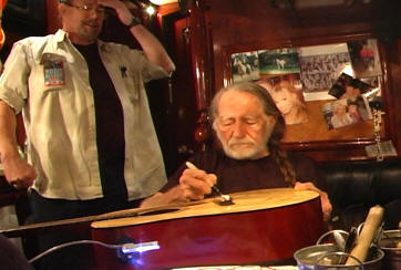 Willie Nelson Signs Guitar for OFFE Raffle